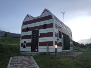 A red and white striped cabin in the shape of a cat